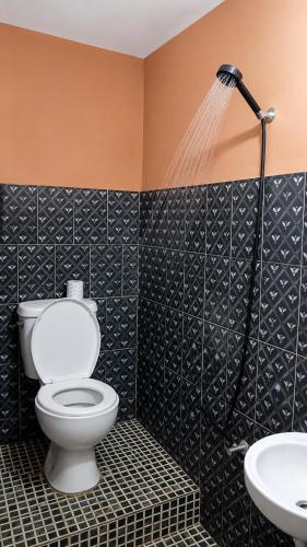 a bathroom with a toilet and a sink at CHAMBRE LA TERRASSE Nosy-be in Hell-Ville