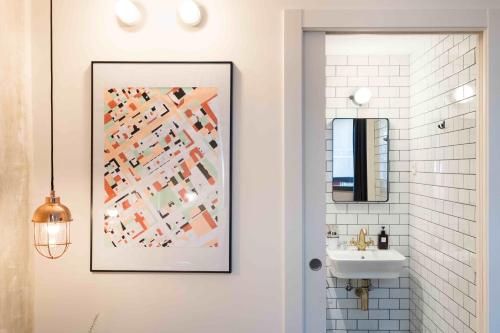 a bathroom with a picture on the wall next to a sink at Magatzem 128 in Barcelona