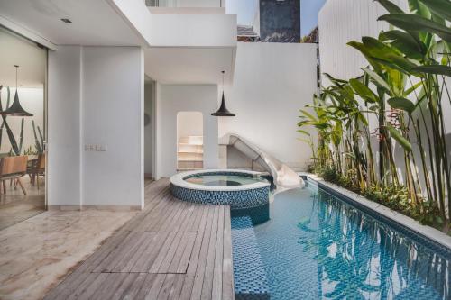 an indoor swimming pool with a slide in a house at Eight Palms Villa Seminyak by Ini Vie Hospitality in Seminyak