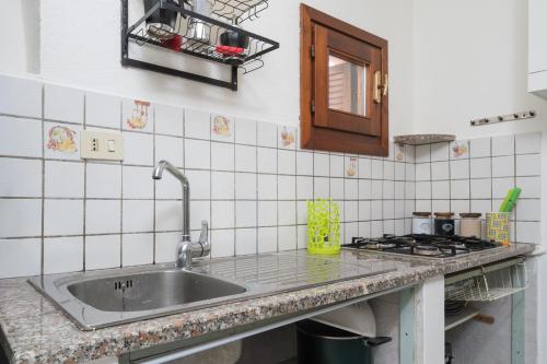a kitchen counter with a sink and a stove at Villa Rosa in Olbia