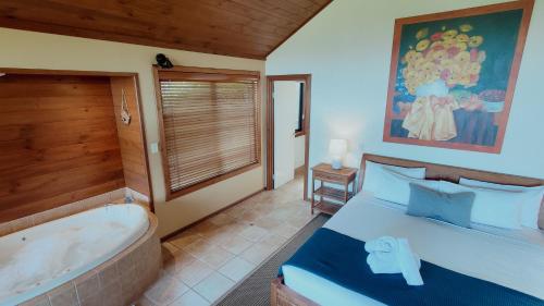 a bedroom with a tub and a bed and a tub at Denmark Scenic Tourist Park in Denmark