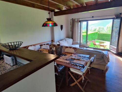a kitchen and living room with a table and a couch at Casa Adosada en Alp Jardin y Wifi in Alp