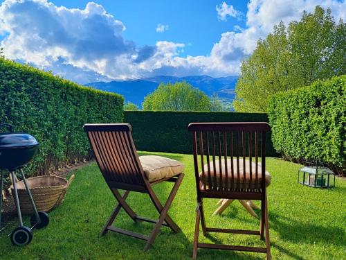 two chairs sitting in the grass next to a grill at Casa Adosada en Alp Jardin y Wifi in Alp