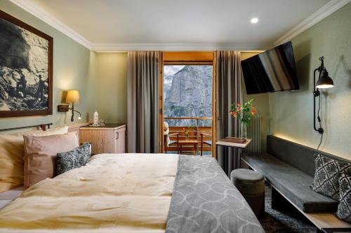 a hotel room with a large bed and a window at Eiger Mürren Swiss Quality Hotel in Mürren