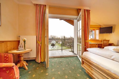 a hotel room with a bed and a balcony at Landhotel Grüner Baum in Westendorf