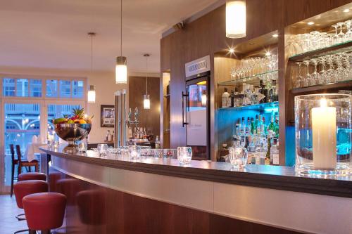 a bar in a restaurant with glasses on the counter at Hotel Villa Belvedere in Binz