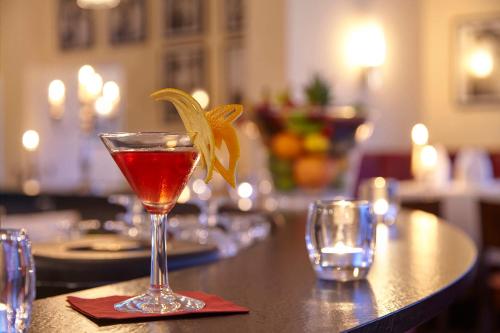 a drink in a glass with a flower on a bar at Hotel Villa Belvedere in Binz