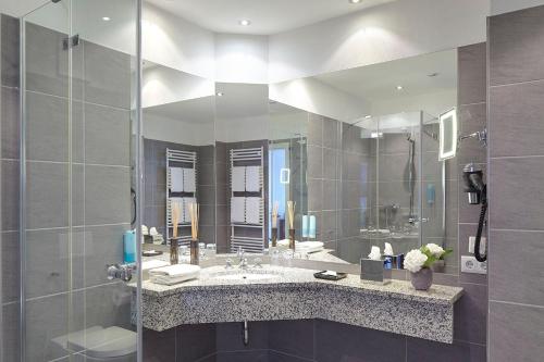 a bathroom with a sink and a large mirror at Hotel Villa Belvedere in Binz