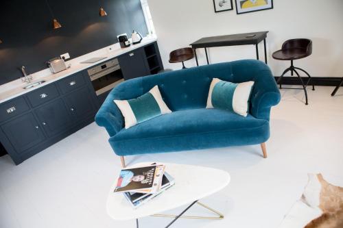 a blue couch in a living room with a table at Book Heaven in Bridport