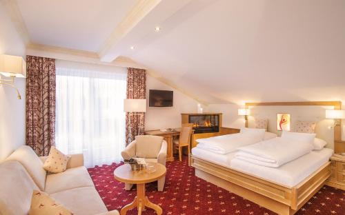 a hotel room with a bed and a couch at Alpenhotel Karwendel -Adults only- in Leutasch