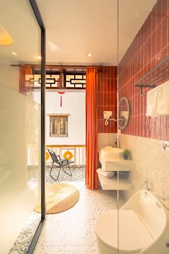 a bathroom with a toilet and a glass shower at Bao An Home old Town in Hoi An