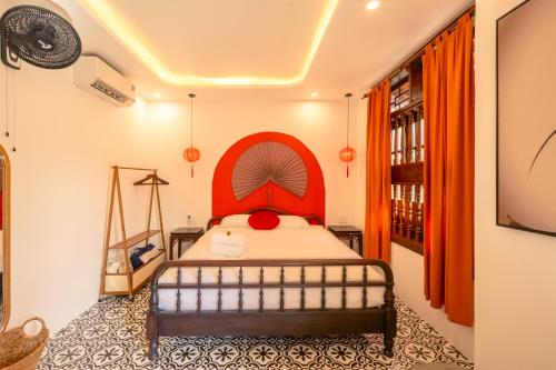 a bedroom with a bed with a red headboard at Bao An Home old Town in Hoi An