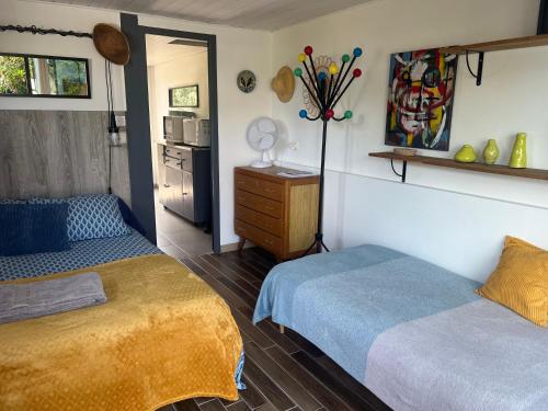 a bedroom with two beds and a kitchen in it at Gîte PAPYRUS in Sainte-Eulalie-en-Born