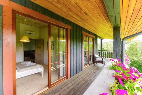 a porch of a house with a bed and a bedroom at Luokesų Dvaro sodyba in Ažuluokesa