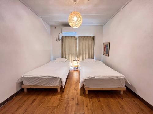 two beds in a hospital room with a window at 北浜 港近くの個室ステイ in Takamatsu