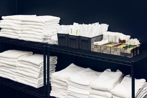 a bunch of white towels on shelves in a room at Montana Wing Yebisu in Osaka