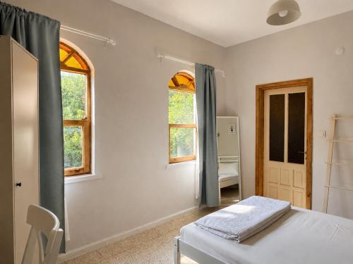 a bedroom with a bed and two windows at Sea Salt Inn in Kemer