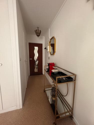 a hallway with a table and a mirror and a door at Studio centre ville in Évreux