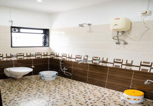 a bathroom with a toilet and a sink at Attra Farms in Karjat
