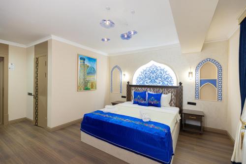 a bedroom with a large bed with blue accents at Boutique Hotel IMONA in Samarkand