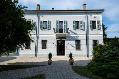 a large white house with a black door at Le Dolci Dimore in Virgilio