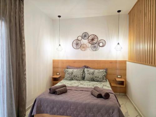 a bedroom with a large bed with two brown pillows at Anthouli Homes 1, steps from beach and centre in Kardamaina