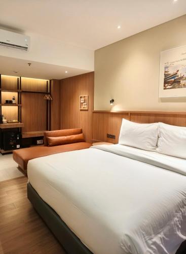 a bedroom with a large white bed and a desk at Samai Suites in Bandar Lampung
