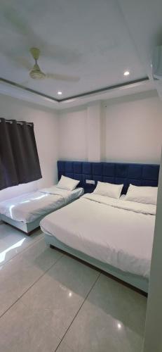a room with two beds in a room with a ceiling at Hotel Durga Palace in Ujjain