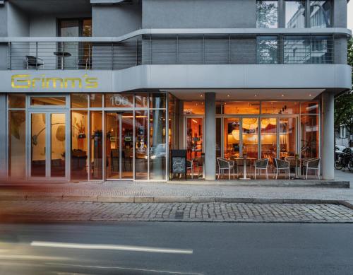 Ein Ladenlokal mit Tischen und Stühlen in der Unterkunft Grimm's Berlin Mitte in Berlin