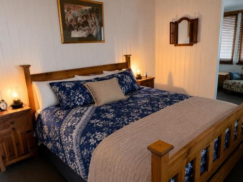 a bedroom with a large bed with blue and white sheets at Dillons Cottage in Stanthorpe