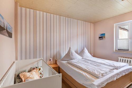 a small bedroom with a crib and a bed at Ferienwohnung Waldglück in Lauchhammer