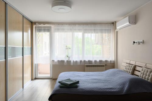 a bedroom with a bed and a large window at Algirdo Apartments, Self Check-in, Free Private Parking in Vilnius