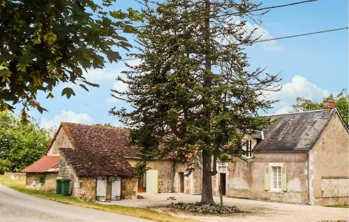 an old stone house with a tree in front of it at Cottage À La Campagne in Mérigny