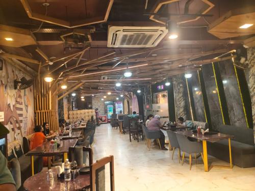 a restaurant with people sitting at tables in a room at Manjeet Hotel & Restaurant in Ballia