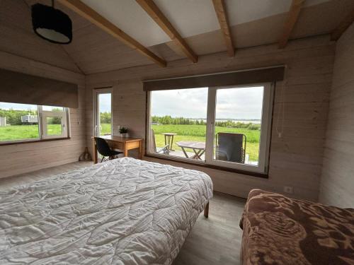 a bedroom with a bed and a large window at Atpūtas vieta Friči in Līguti
