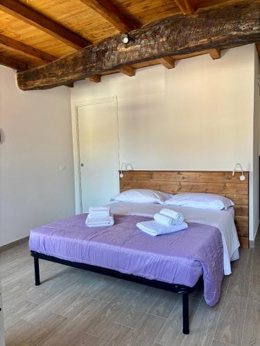 a bedroom with a purple bed with towels on it at Affittacamere Ca' Vecia in Riccò del Golfo di Spezia