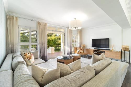 a living room with a couch and a television at Winelands Golf Lodges 3 in Stellenbosch