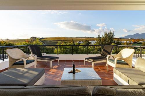 a living room with a couch and chairs on a balcony at Winelands Golf Lodges 3 in Stellenbosch