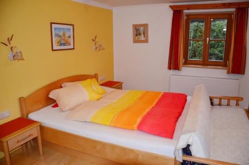 a bedroom with a bed with a colorful blanket at Kleintödlinggut in Leogang