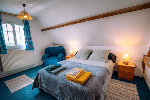 a bedroom with a bed and a blue chair at Gîte de caractère - La Grangette in Saint-Julien-le-Faucon