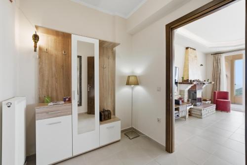 a large mirror in a white room with a living room at Villa Sarakinos in Kriniás