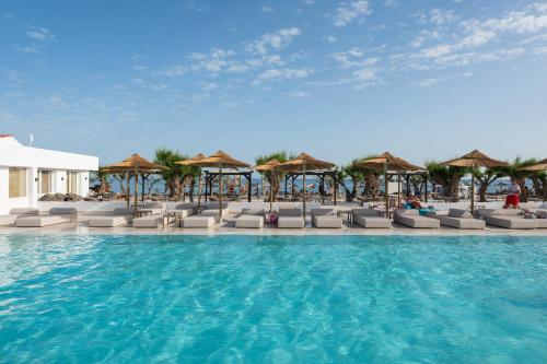 a swimming pool with chairs and umbrellas at Sun Beach Lindos in Lartos