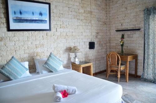 a bedroom with a white bed and a table with a chair at Eden Resort in Santander