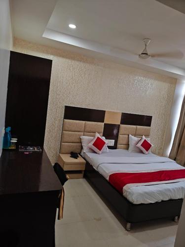 a bedroom with a large bed and a desk at Hotel Travora Suits -Lalquila in Bhubaneshwar