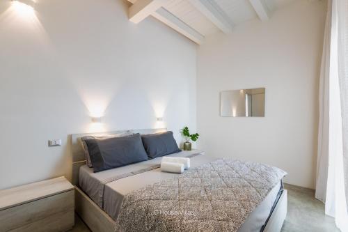 a bedroom with a bed in a white room at Elaia Bioglam Relais in Casa Modica
