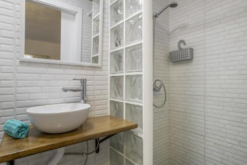 a white bathroom with a sink and a shower at Vejer de la frontera 100 pza España in Vejer de la Frontera