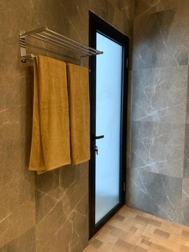a bathroom with a mirror and a shower door at Cozzy Sagas House Tabanan in Perean