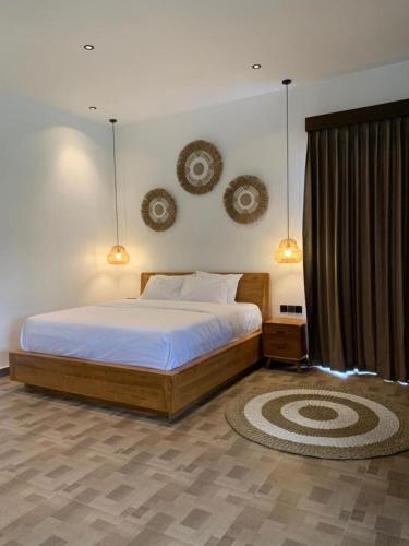 a bedroom with a bed and two mirrors on the wall at Cozzy Sagas House Tabanan in Perean