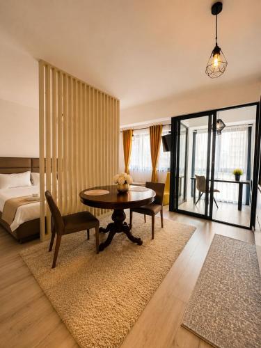 a living room with a table and a bed at Zen studio near Mall Moldova in Iaşi