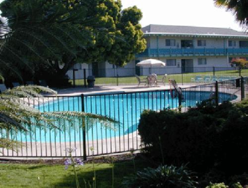 una gran piscina azul con una valla alrededor en Coral Reef Inn & Condo Suites, en Alameda